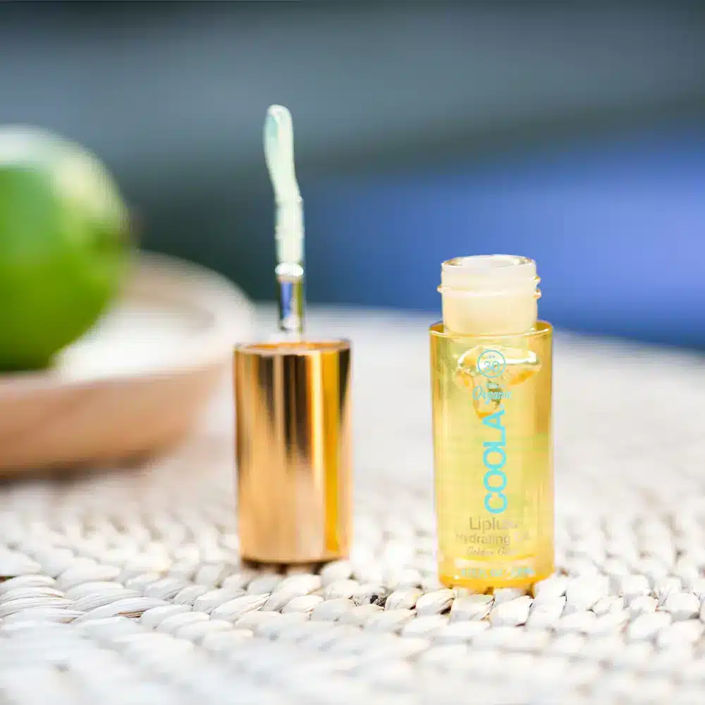 COOLA liplux hydrating oil lifestyle flatlay CL10427